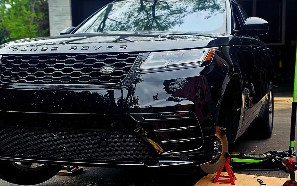 A Range Rover raised for mobile vehicle service outside a garage